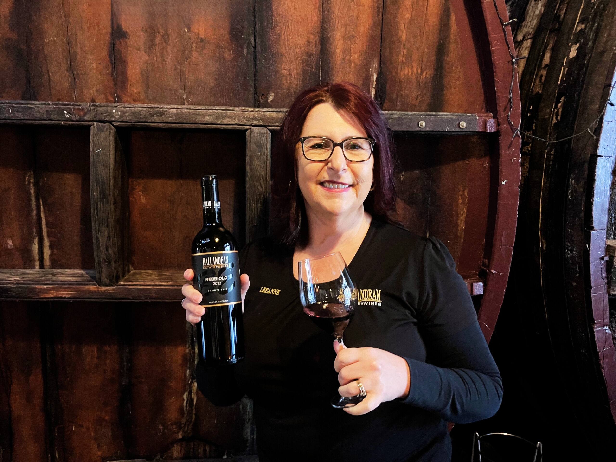 Leeanne holding a bottle of Nebbiolo wine